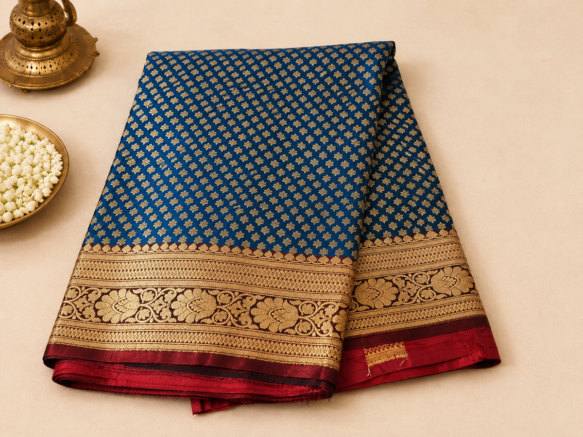 Teal blue Banarasi silk saree – folded view showing dense all-over gold booti pattern and wide woven gold border with red pallu