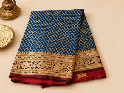 Teal blue Banarasi silk saree – folded view showing dense all-over gold booti pattern and wide woven gold border with red pallu