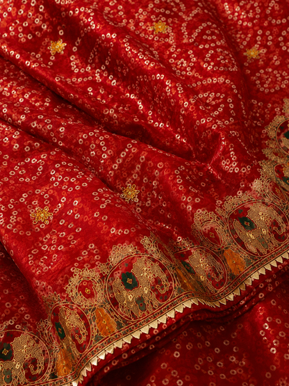 Red bandhani georgette saree – fabric close-up showing dense bandhani dot pattern, gold sequin motifs and elephant embroidered border