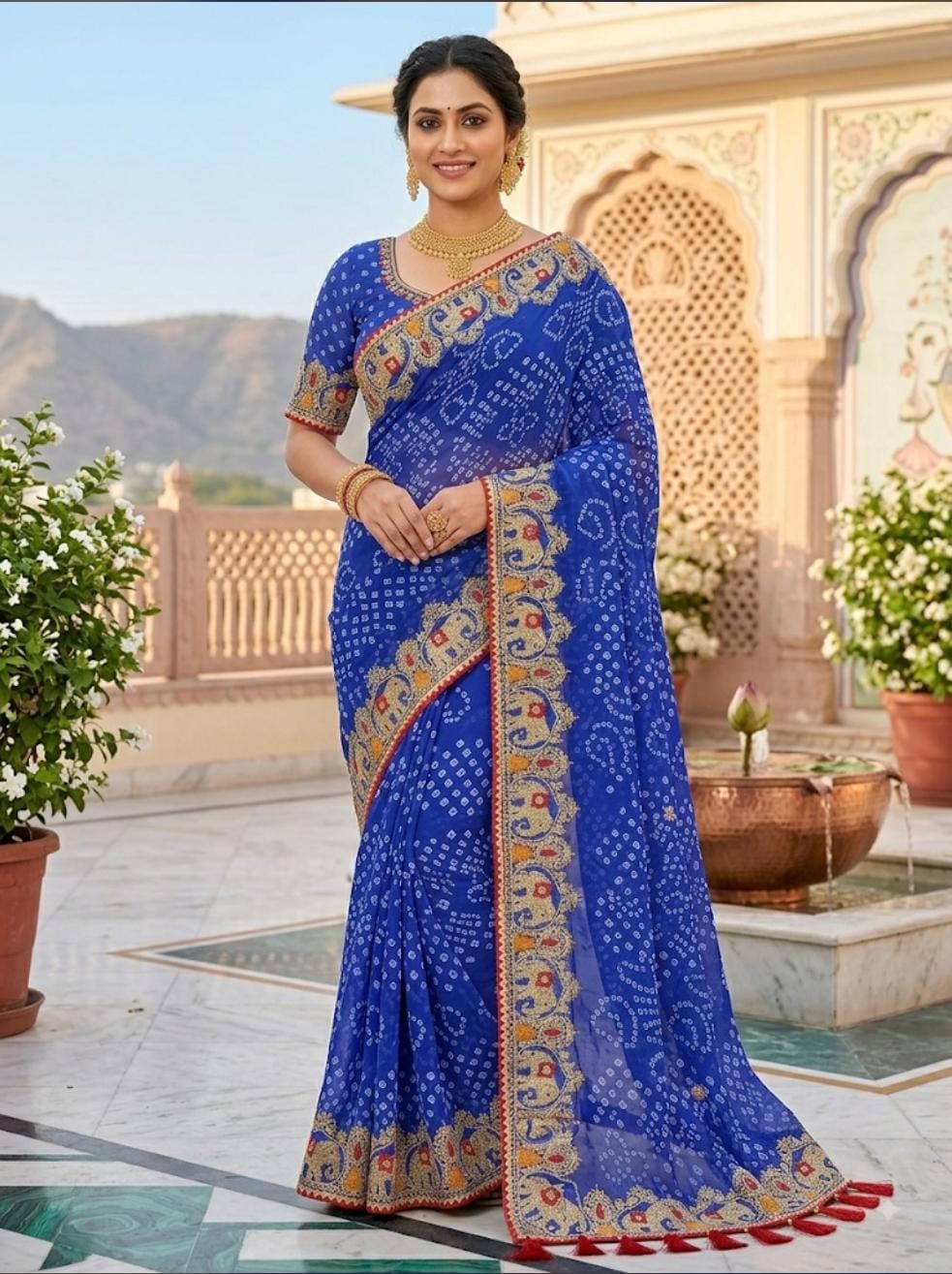 Royal blue bandhani georgette saree – model standing view showing gold elephant embroidered border and red tassels